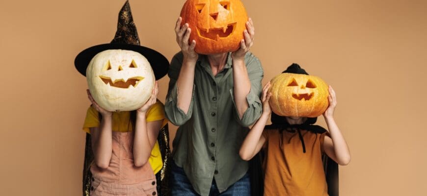 Playful,Family,Wearing,Costumes,Posing,And,Having,Fun,,Holding,Carved